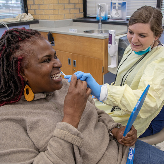 Dental student brushes woman's teeth